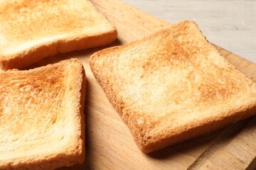 Slices of delicious toasted bread on wooden table, closeup