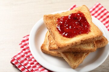Delicious toasted bread slices with jam on wooden table