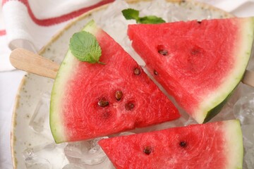 Pieces of tasty watermelon, ice cubes and mint on table, top view