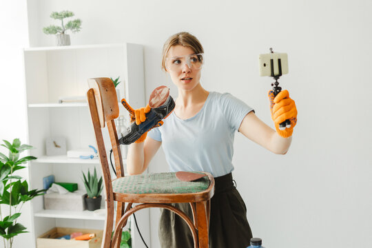 Carpenter woman is recording diy furniture restoration video blog using smartphone