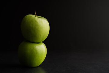 Close-up of granny smith apples on table against black background