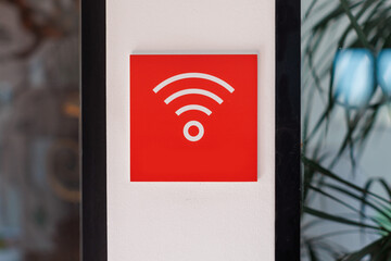 Wi-Fi signal indicator on a wall in a modern cafe indicating internet availability during daytime