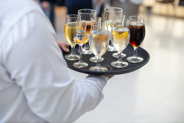 Waiter carrying a tray of assorted drinks at a formal event