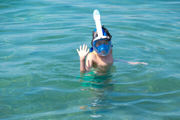 Teenage boy enjoying snorkeling in sea water, enjoying active summer holidays, exploring underwater...