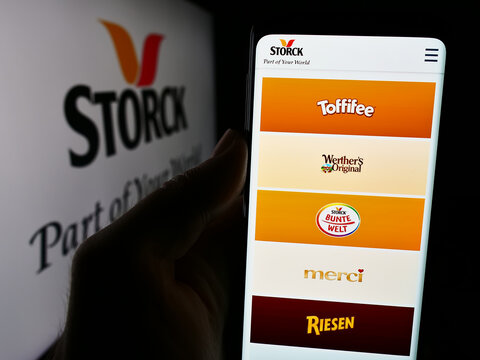 Stuttgart, Germany - 08-07-2024: Person holding smartphone with webpage of German confectionery company August Storck KG in front of logo. Focus on center of phone display.