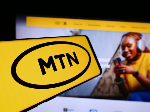 Stuttgart, Germany - 08-07-2024: Cellphone with logo of South African telecommunications company MTN Group Limited in front of website. Focus on center-left of phone display.