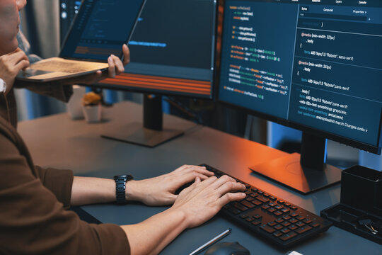 Serious of IT developers discussing intelligent website development coder system running data online two screens with laptop showing information network at neon light room at modern office. Infobahn.