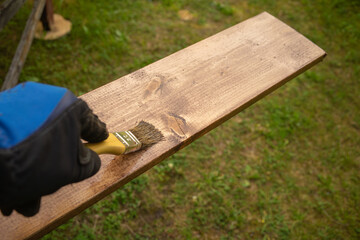 Applying an impregnation to protect the wooden surface.Painting a construction board with a brush.Antiseptic for wood.