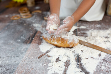 a child makes a croissant in flour
