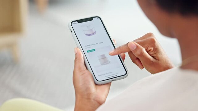 Shopping online and scrolling through makeup products to find a sale or discount. Hands of a woman browsing cosmetics on her phone from above. Enjoying the convenience and ease of purchasing apps