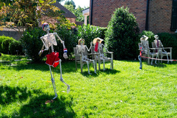 Halloween decorations on the lawn in front of the house. Skeletons playing tennis.