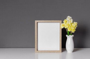 Blank wooden photo frame mockup with flowers, blank frame with copy space over grey wall