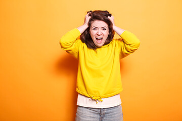 Frustrated and angry woman makes an exasperated hand gesture. Furious young stressed person having a nervous breakdown, acting aggressively and displaying an unpleasant reaction.