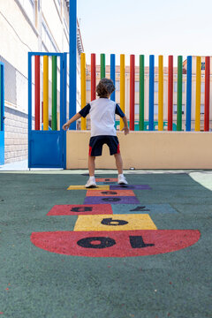 Little boy playing hopscotch at school