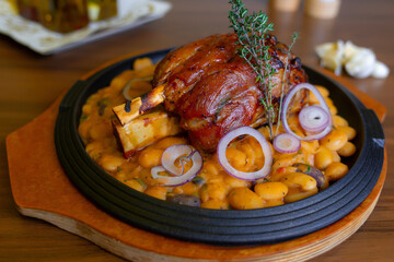 Pork knuckle with beans on cast iron