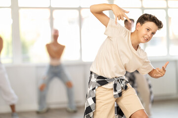 Group of sporty teenagers practicing hip-hop dance in training hall during dancing classes