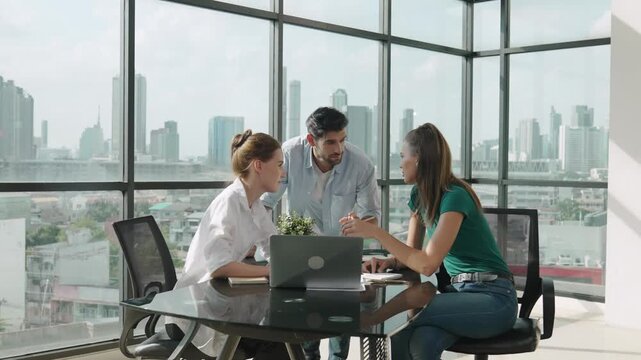 Group of skilled businesspeople sharing idea about marketing plan. Professional business team working together, discussing, talking at meeting table with laptop, document with cityscape. Tracery