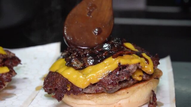 chef making doble smashed burger with bacon jam and mayo