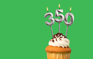 Birthday with number 350 candle and cupcake - Anniversary card on green color background