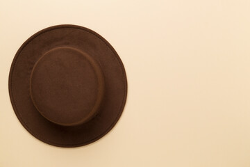 Brown autumn hat on color background, top view