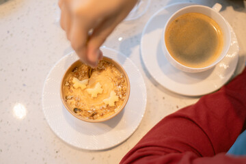 Woman eating delicious dessert with coffee in coffee shop