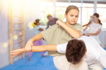 Fototapeta premium Preteen children pairs learning strength self-defense in the gym