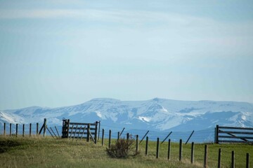 A Fenced In Area With A Mountain In The Background.