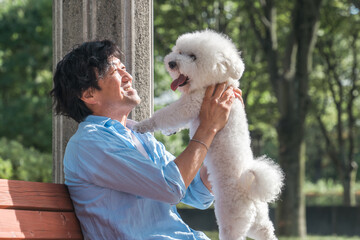 犬の散歩をする愛犬家の中高年男性・ドッグセラピー（抱く・抱っこ）
