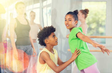 Couple teenage boy and girl dancers rehearsing pair ballet in studio