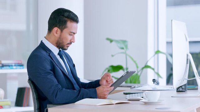 Annoyed male looking frustrated, upset with slow internet and bad connection while browsing. Angry businessman trying to cancel a subscription on a digital tablet while sitting in a modern office.