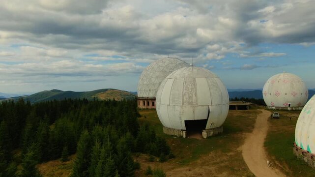 Pamir old military radar station. Aerial view of abandoned secret army site, former radio locating station, Carpathian mountains, Ukraine. Futuristic architecture buildings in forest.