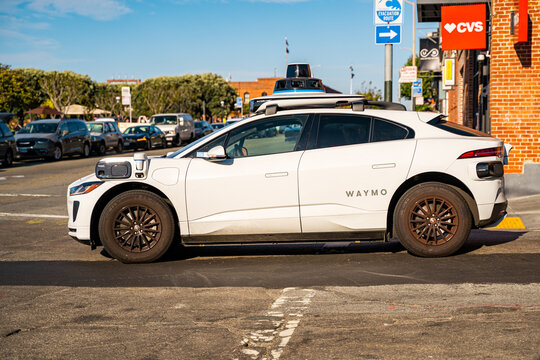 A Waymo robotaxi drives through the city without a human driver.