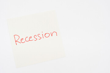 Hand writing Recession on paper note. Global economic crisis. Recession business and stock crisis concept.