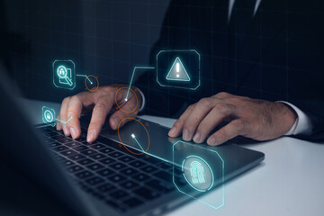 A man is typing on a laptop with a green screen that has a fingerprint symbol on it. Concept of security and protection, as the fingerprint symbol is often used to identify individuals