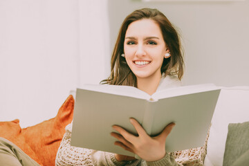 Woman reading book, smiling, bright inviting atmosphere