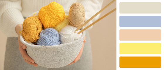 Woman holding basket with knitting yarn and needles on color background