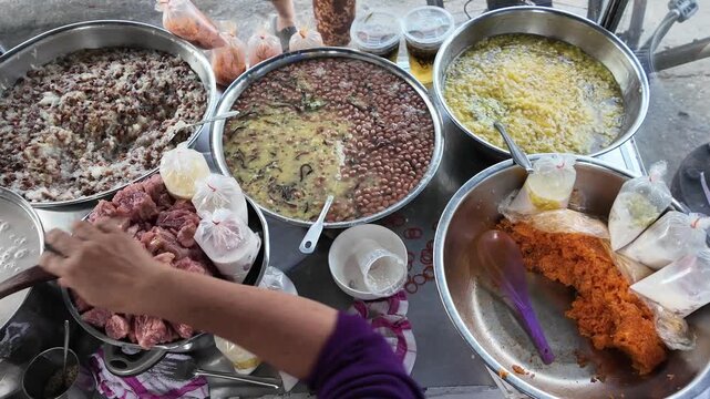 Vietnamese street food, sweet soup is tradition desserts, woman hand scooping che, sugared dishes from deverse bean, banana and coconut milk at outdoor stalls