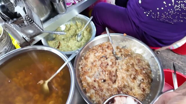 Vietnamese street food, sweet soup is tradition desserts, woman hand scooping che, sugared dishes from deverse bean, banana and coconut milk at outdoor stalls