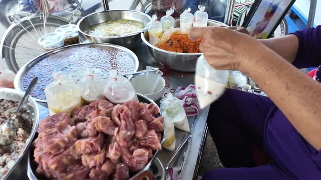 Vietnamese street food, sweet soup is tradition desserts, woman hand scooping che, sugared dishes from deverse bean, banana and coconut milk at outdoor stalls