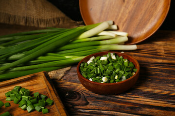 Bowl with fresh cut green onion on table