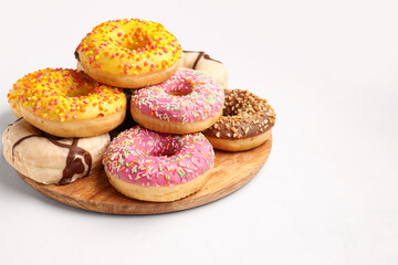 Board with sweet donuts on white background