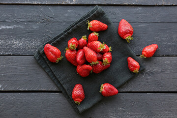 Fresh strawberries on black wooden background