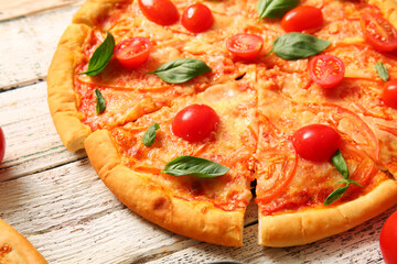 Tasty pizza margarita on white wooden background
