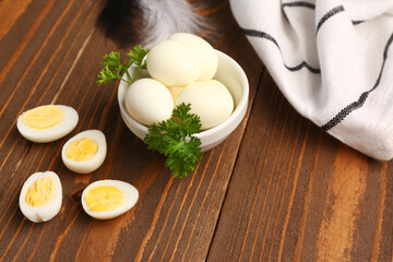 Bowl with boiled quail eggs on wooden background