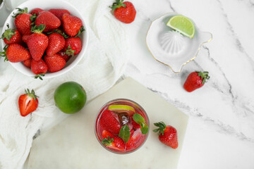 Glass of delicious strawberry mojito on light background