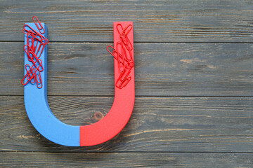 Magnet with paper clips on dark wooden background