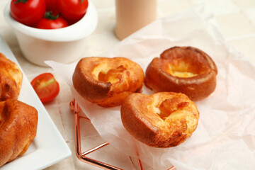 Cooling rack with tasty Yorkshire pudding on light tile background
