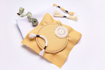 Embroidery hoop with canvases, measuring tape and mouline threads isolated on white background