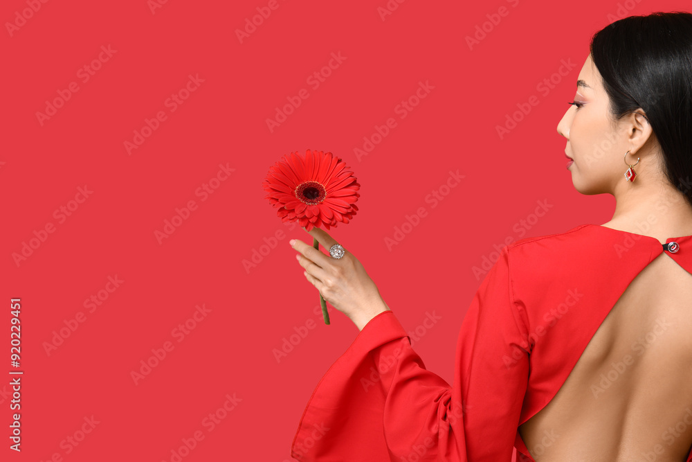 Canvas Prints Pretty young Asian woman with beautiful gerbera flower on red background