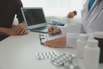 Fototapeta premium Doctor prescribing medicine giving pills to senior grandmother patient at hospital.
